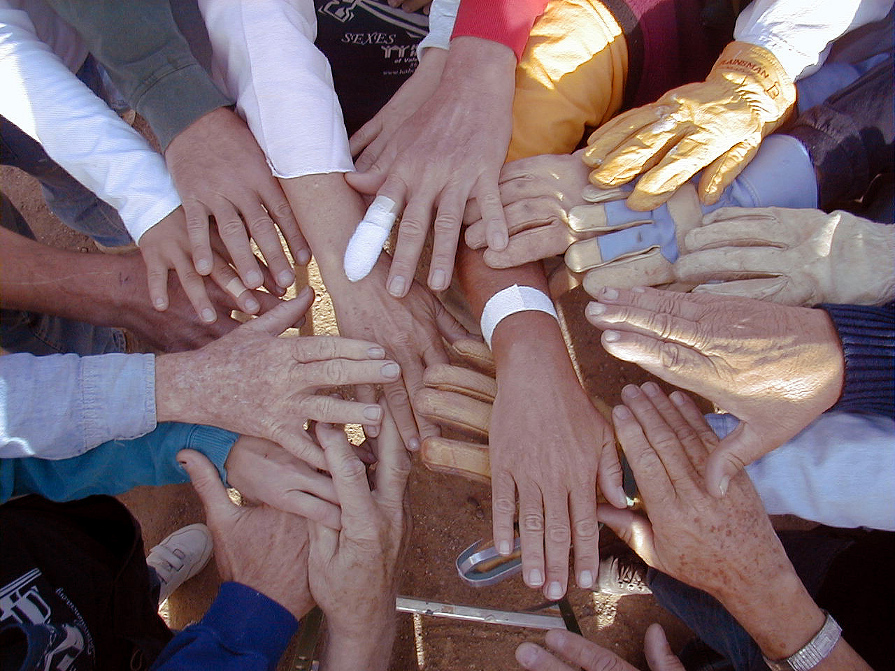 Image depicting a team holding hands in a circle.